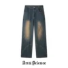 Front flat lay view of deep indigo vintage wash denim trousers featuring unique diagonal panel stitching and tan-toned fading.