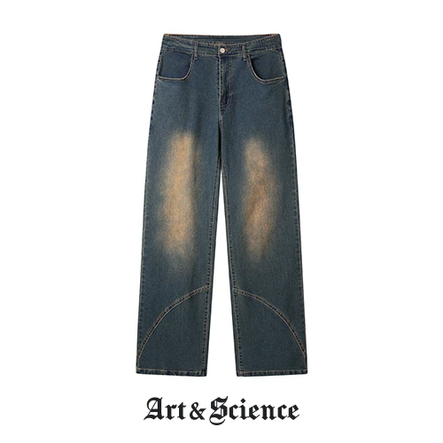 Front flat lay view of deep indigo vintage wash denim trousers featuring unique diagonal panel stitching and tan-toned fading.